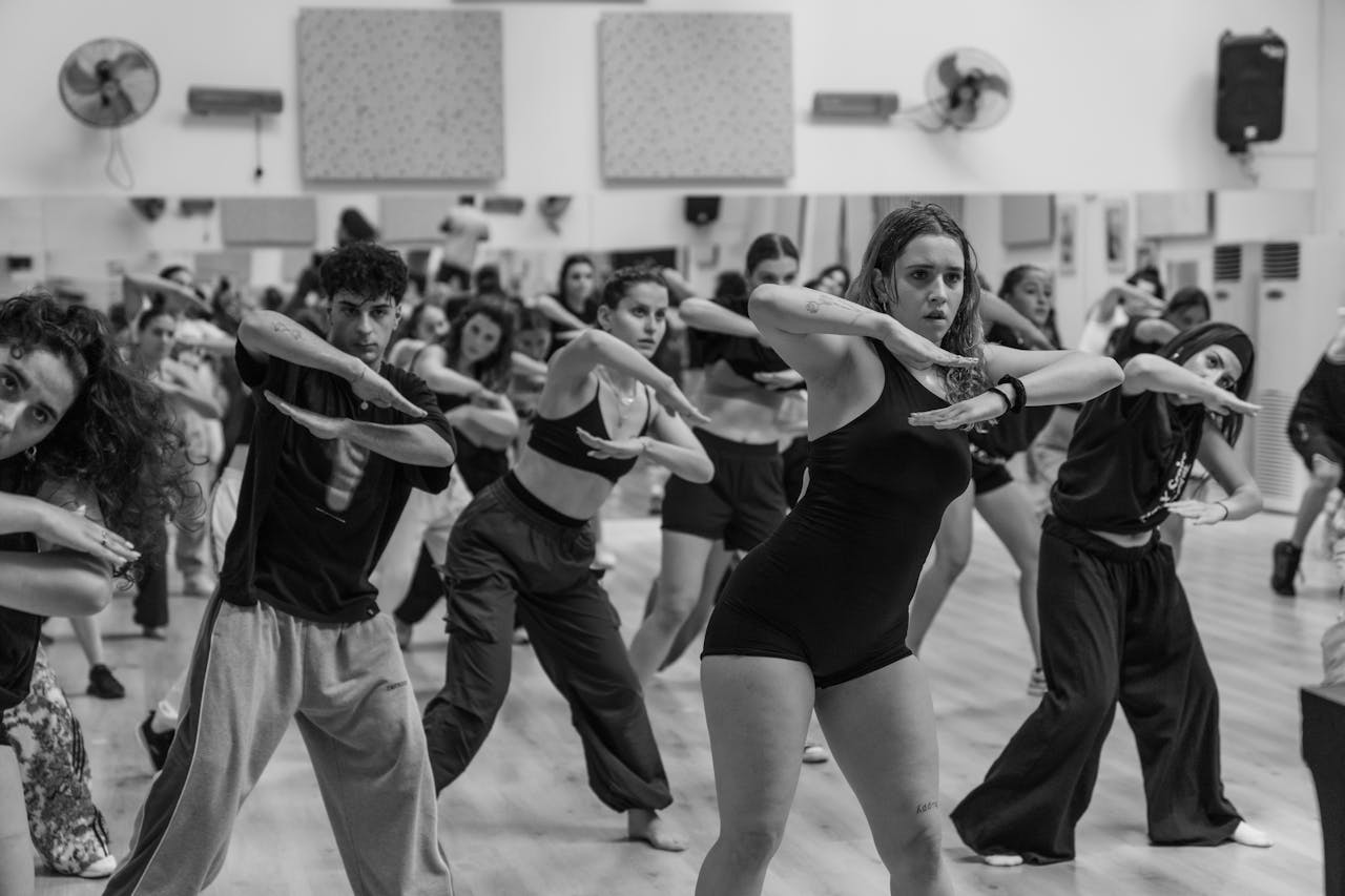 Energetic group dance class with diverse participants expressing vibrant choreography.